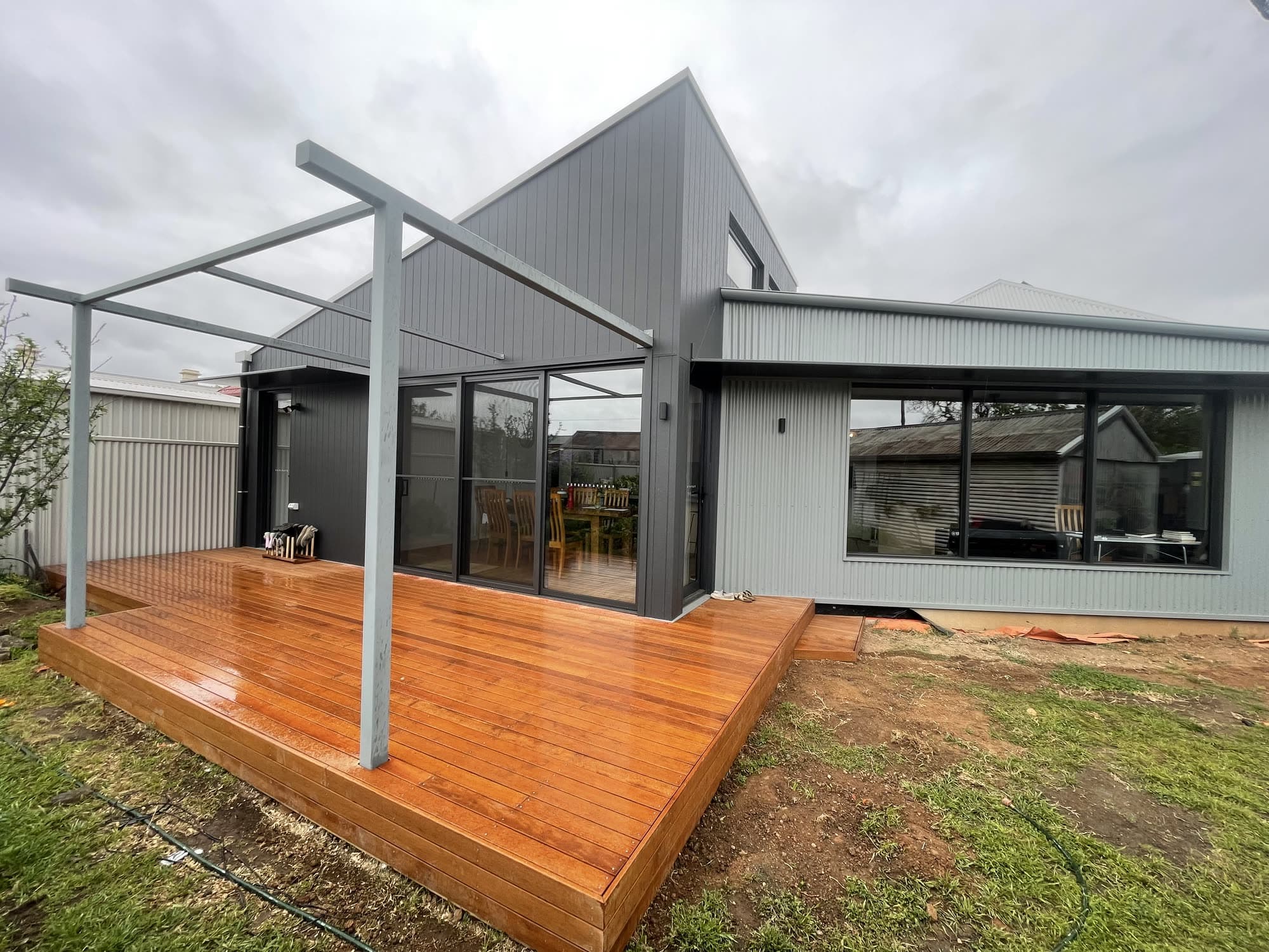 Modern extension with a merbau deck and steel pergola frame