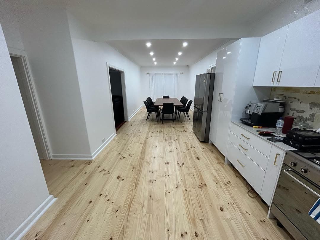 Renovated open plan kitchen with pale timber flooring