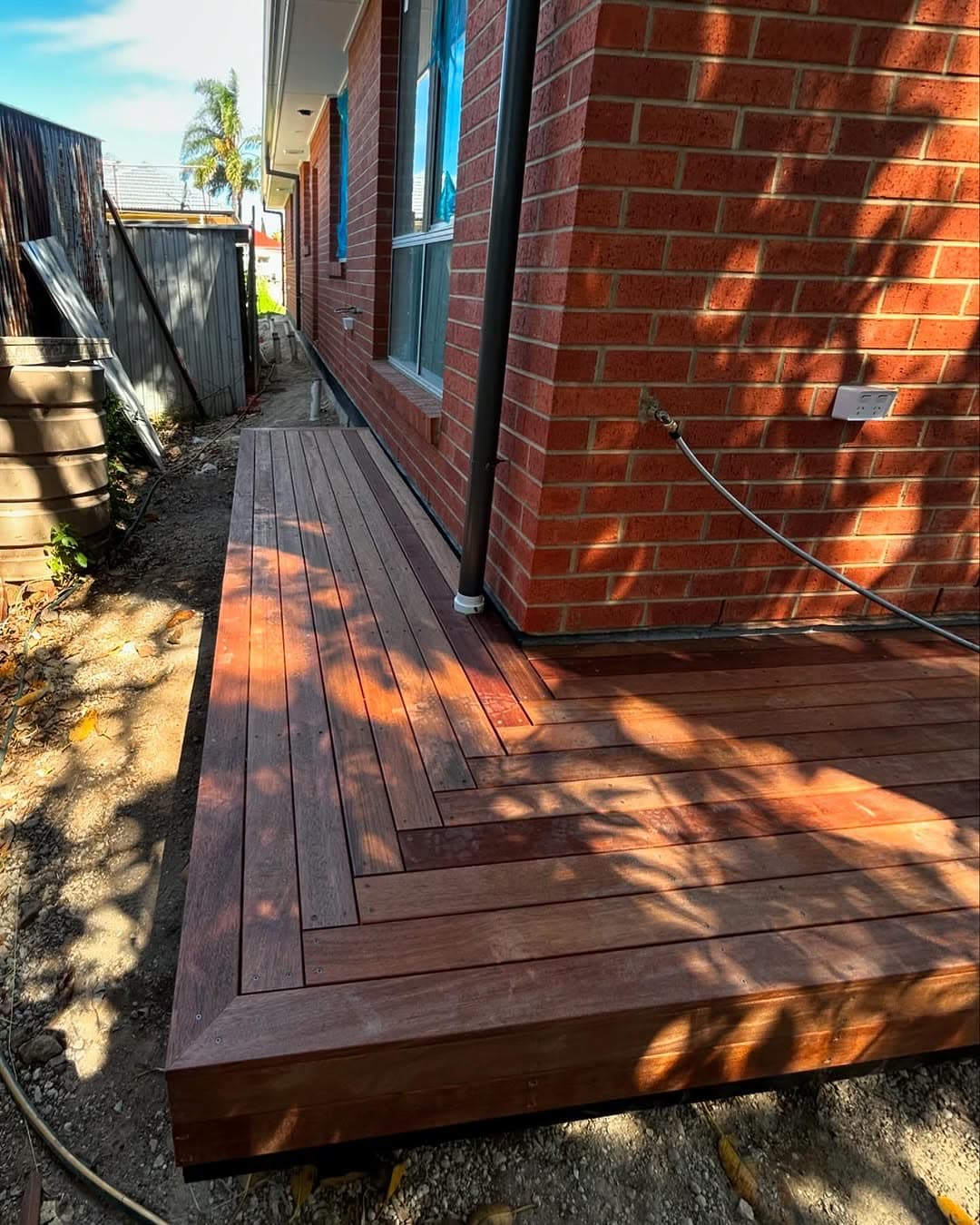 Hardwood deck stepped around the corner of a red brick home