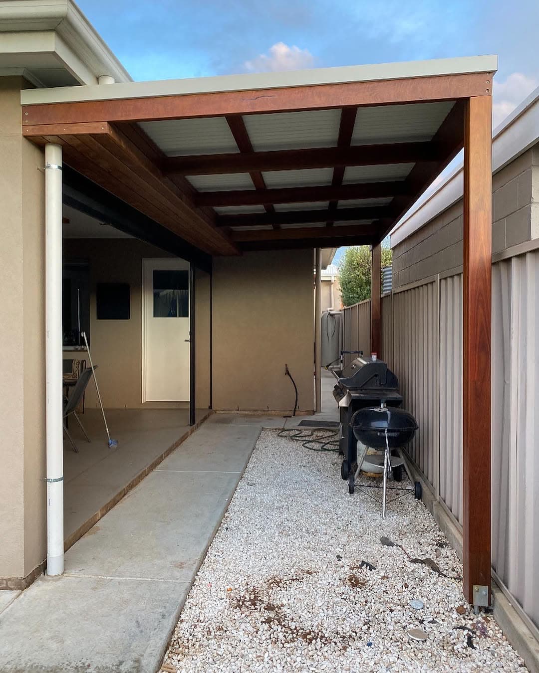 Timber-framed pergola walkway running along the side of a house
